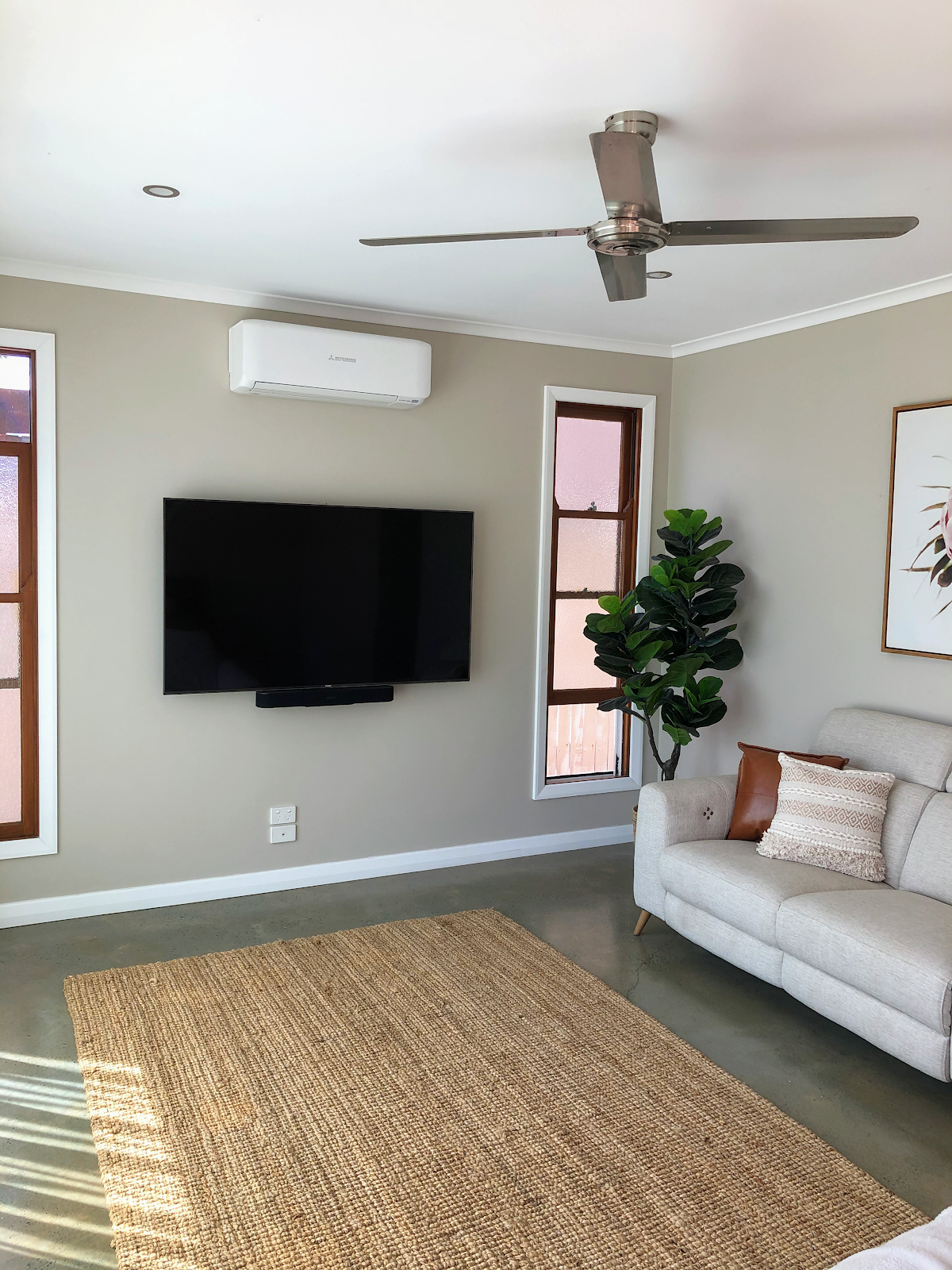 TV and soundbar on the wall, split system above, fan and downlight